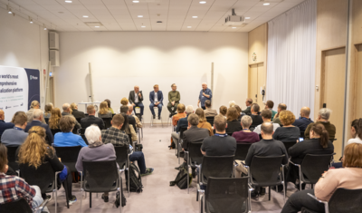 conference room people sitting and listening to a panel discussion