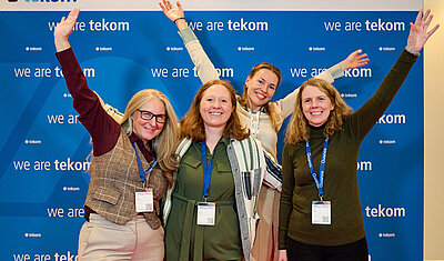 tekom Ireland members with tekom Europe community manager in front of a "we are tekom" poster wall